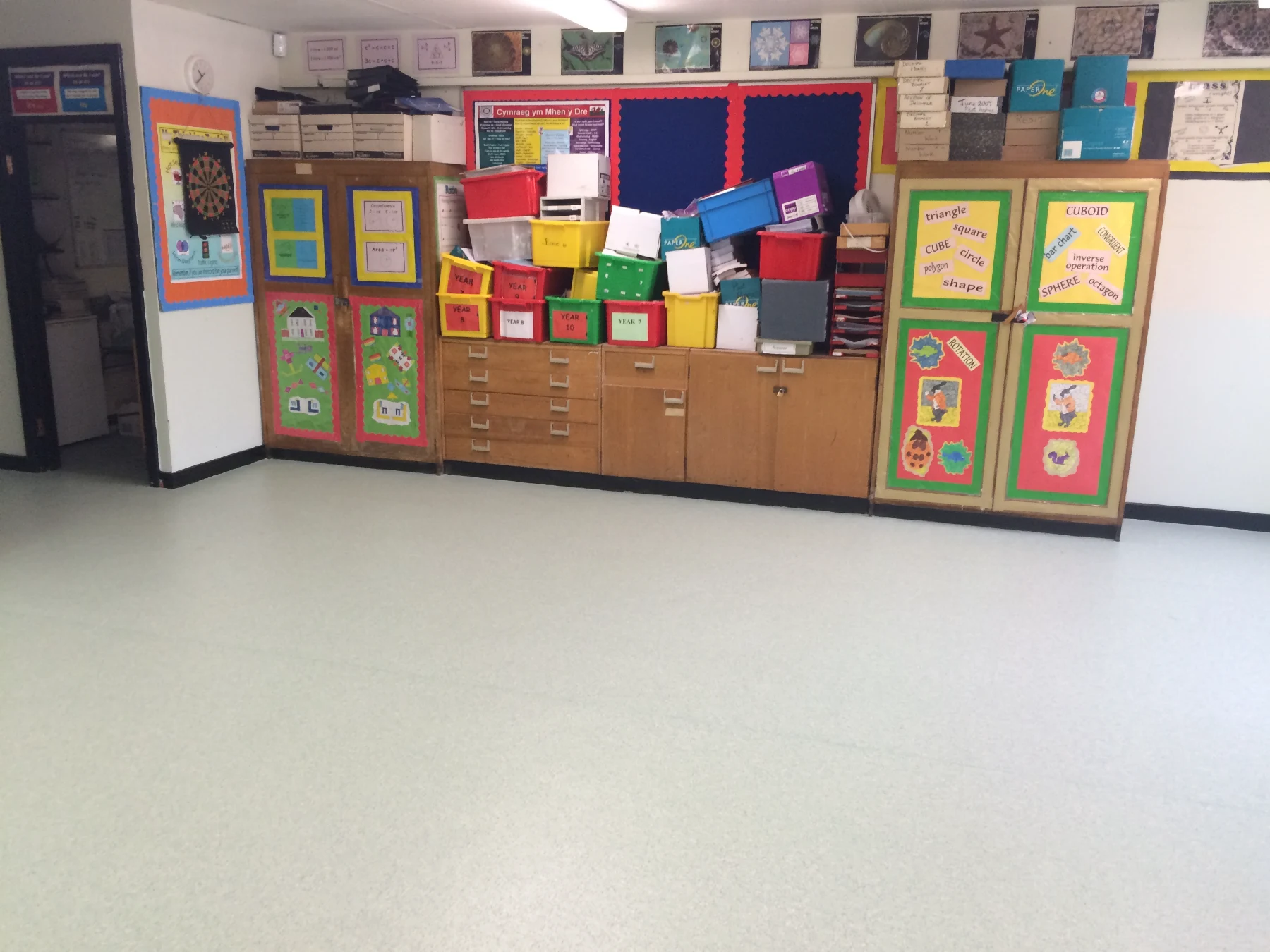 A flawless execution of high-traffic commercial flooring designed to withstand decades of heavy school use. Our expert fitting team installed slip-resistant safety vinyl throughout this primary school classroom, prioritising maximum durability and hygiene.  The true hallmark of quality in this installation is the precision perimeter cutting. The vinyl has been flawlessly profiled around the intricate shapes of the built-in desk cabinetry, structural radiator pillars, and door frames, eliminating any awkward gaps where dirt or moisture could collect.  Flooring Type: High-Durability Commercial Safety Vinyl  Sector: Education / Public Sector  Key Craftsmanship: Intricate perimeter scribing around fixed cabinetry & flush seams  Location: South Wales Area