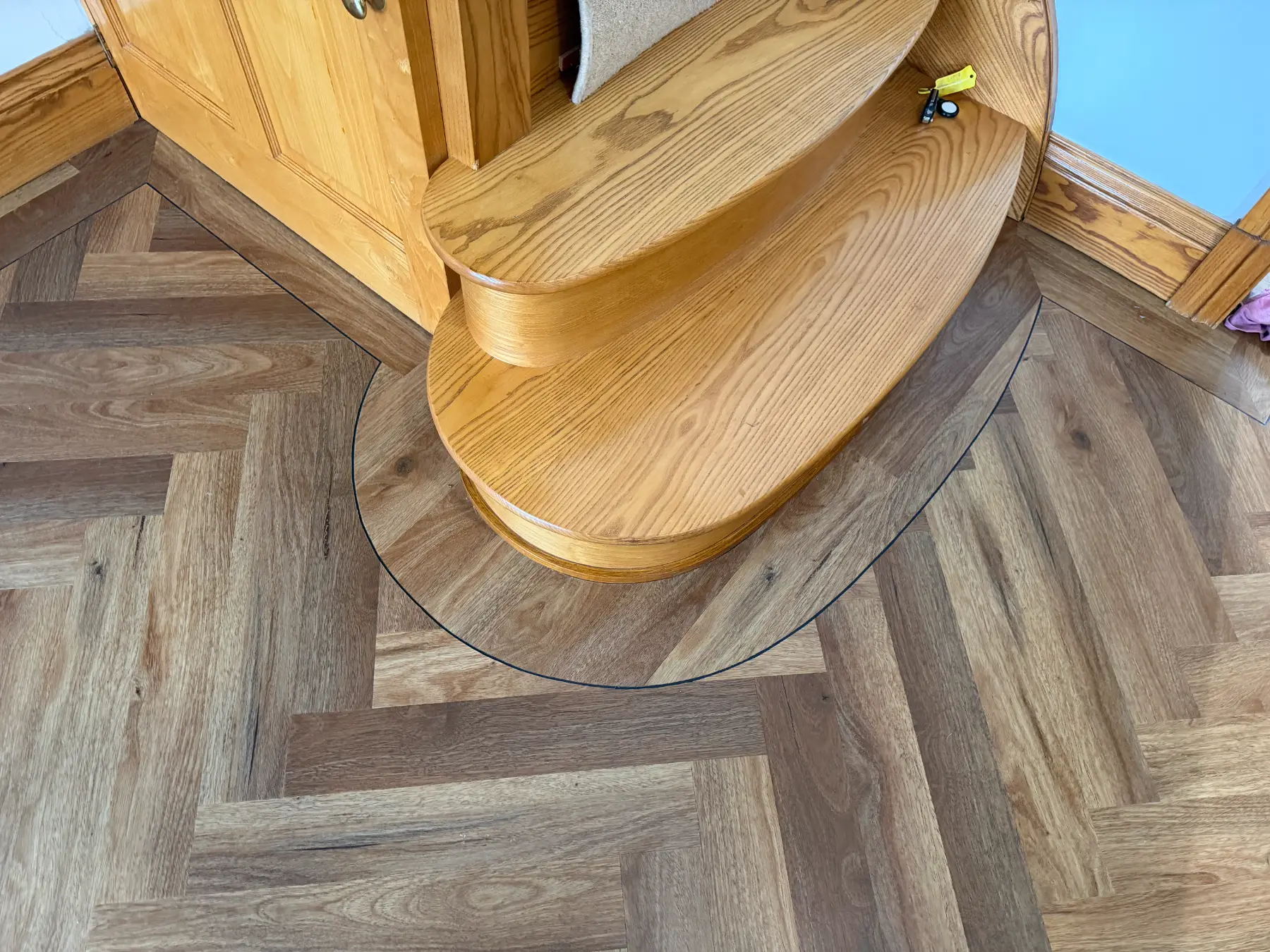 Premium Herringbone Parquet LVT with Curved Bullnose Detailing An absolute masterpiece of bespoke residential flooring installation, expertly fitted by our craftsman Liam. This project required installing a premium, wood-effect Luxury Vinyl Tile (LVT) in a traditional herringbone parquet layout, demanding absolute precision to maintain a flawless geometric pattern across a wide, multi-doorway hallway.  The true signature feature of this installation is the custom-scribed perimeter work surrounding a spectacular double-layer oak bullnose feature step. Liam precision-cut a crisp, dark design strip that effortlessly hugs the sweeping curves of the natural timber woodwork without a single visible gap.  Framed by a perfectly straight matching plank border that follows the intricate lines of the timber skirtings and door architraves, this installation creates a breathtaking, luxury first impression for the home.  Flooring Type: Luxury Wood-Effect Parquet LVT  Design Pattern: Traditional Herringbone Layout with Custom Perimeter Design Strips  Expert Installer: Liam  Key Craftsmanship: Advanced radius scribing around a double curved oak bullnose step & precision threshold transitions  Finish Level: Hand-profiled borders flush against custom timber architraves  Location: South Wales