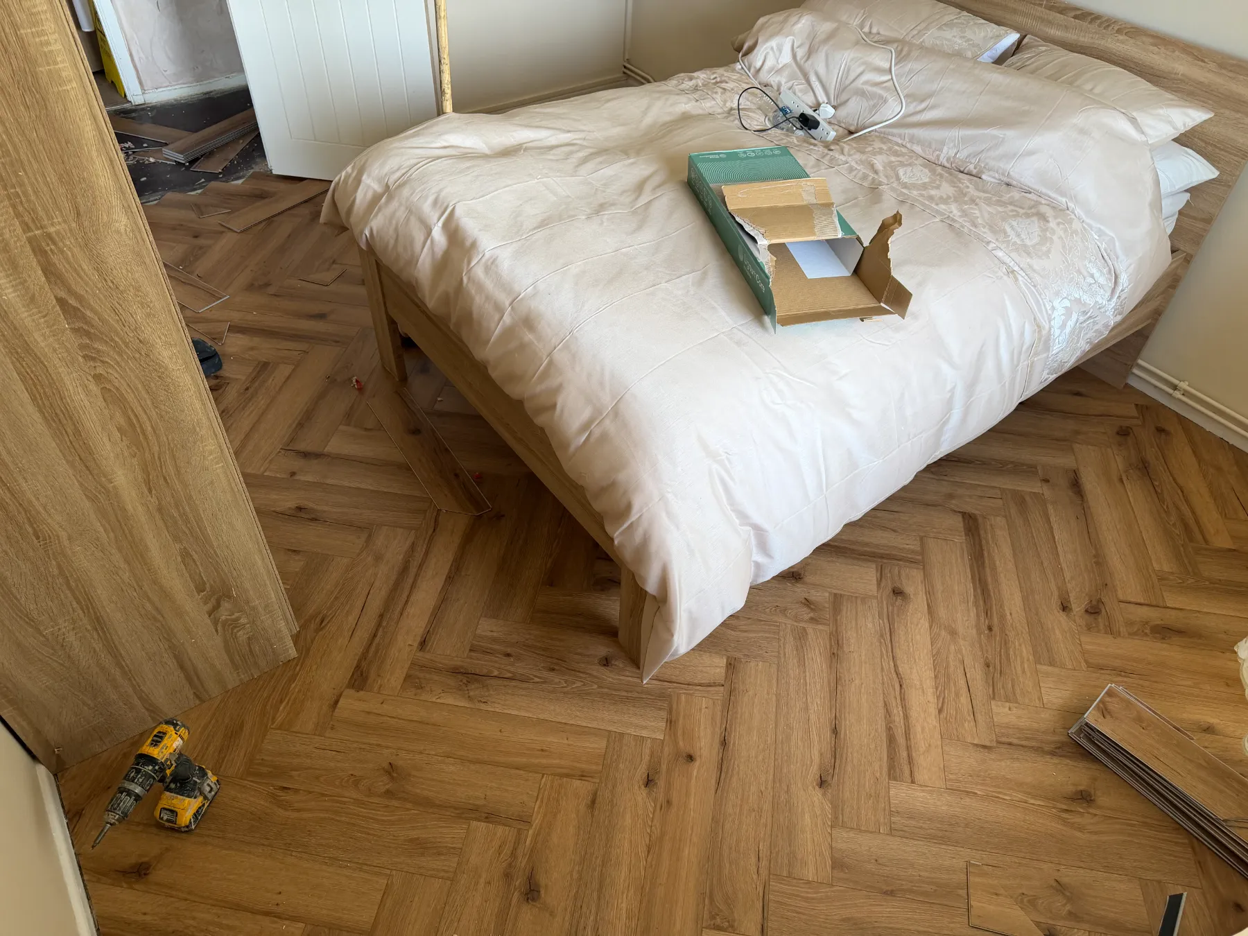 📋 Overview A masterclass in modern geometric flooring design. This project features a premium Herringbone Luxury Vinyl Tile (LVT) installation across a residential master bedroom suite. The job required precision subfloor preparation and intricate border cuts to deliver a seamless, high-contrast wood-grain finish that maximizes natural light and enhances room depth.  🛠️ Technical Breakdown & Craftsmanship The Design Pattern: Traditional 90-degree Herringbone interlocking blocks, creating an authentic parquetry visual with the ultra-durable, waterproof benefits of modern rigid-core LVT.  Precision Border Profiling: Flawless scribing and tight-tolerance cuts directly flush against complex architectural obstacles, including heavy fitted wardrobe plinths, uneven door architraves, and structural bedroom floor supports.  Grain Orientation: Mechanically staggered layout designed to balance the natural timber variegation, completely eliminating repetitive tile pooling and mimicking a genuine wire-brushed oak finish.  💎 Key Features & Material Specs Product Type: Rigid Core SPC / Luxury Vinyl Plank (LVT)  Visual Profile: Natural Honeyed Oak with microbeveled edges for distinct plank definition.  Durability Rating: Commercial-grade wear layer (Heavy Domestic / Light Commercial), fully scratch-resistant and 100% waterproof—perfect for high-traffic domestic bedrooms.  Underfoot Comfort: Advanced acoustic backing integration to minimize impact noise transfer across floor joists.  🏁 The Just Carpets Guarantee "From precision cutting on our warehouse floor to the final plank laid by our fitting teams—we ensure your custom floor is masterfully measured, perfectly cut, and fitted before you know it."